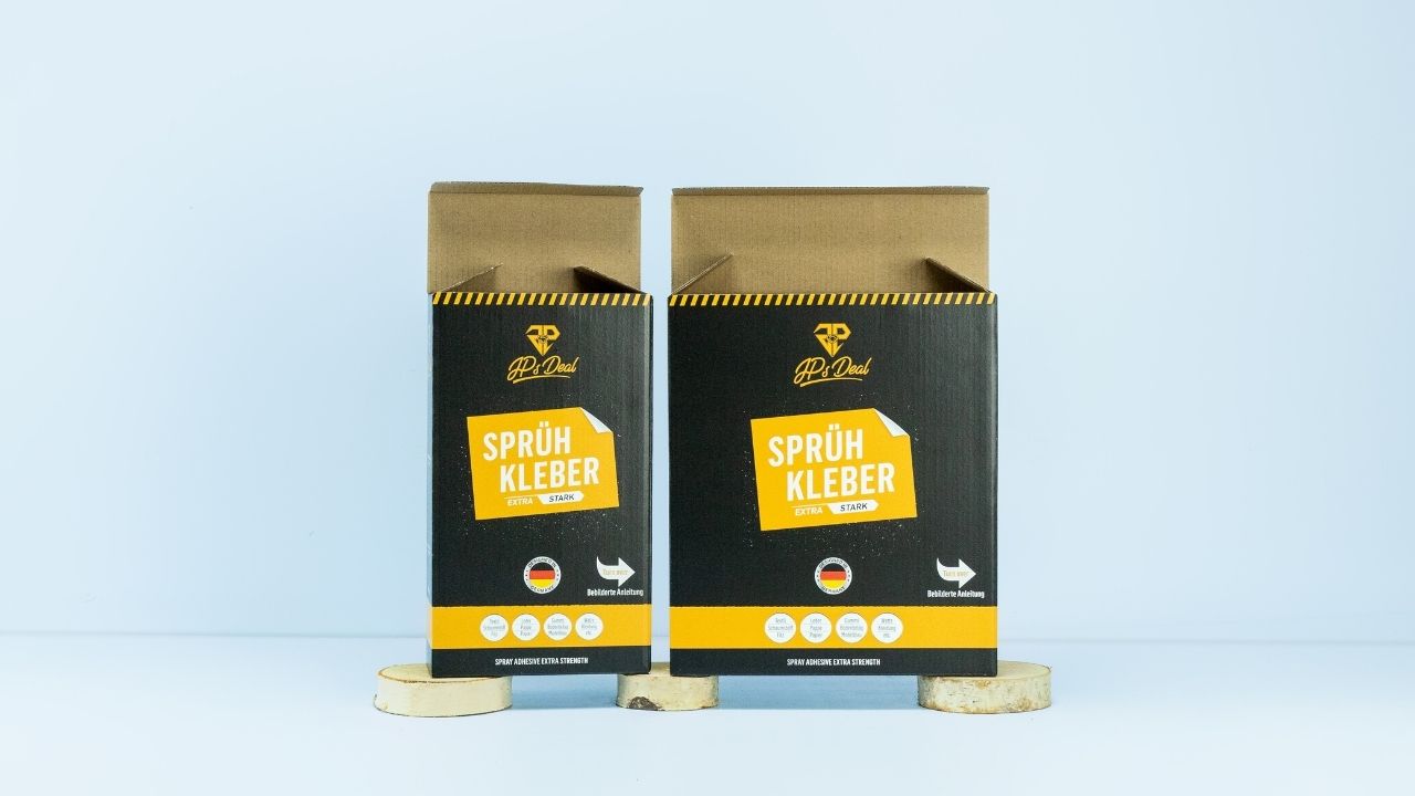 Zwei bedruckte Faltschachteln vor hellblauem Hintergrund Zwei bedruckte Faltschachteln vor hellblauem Hintergrund